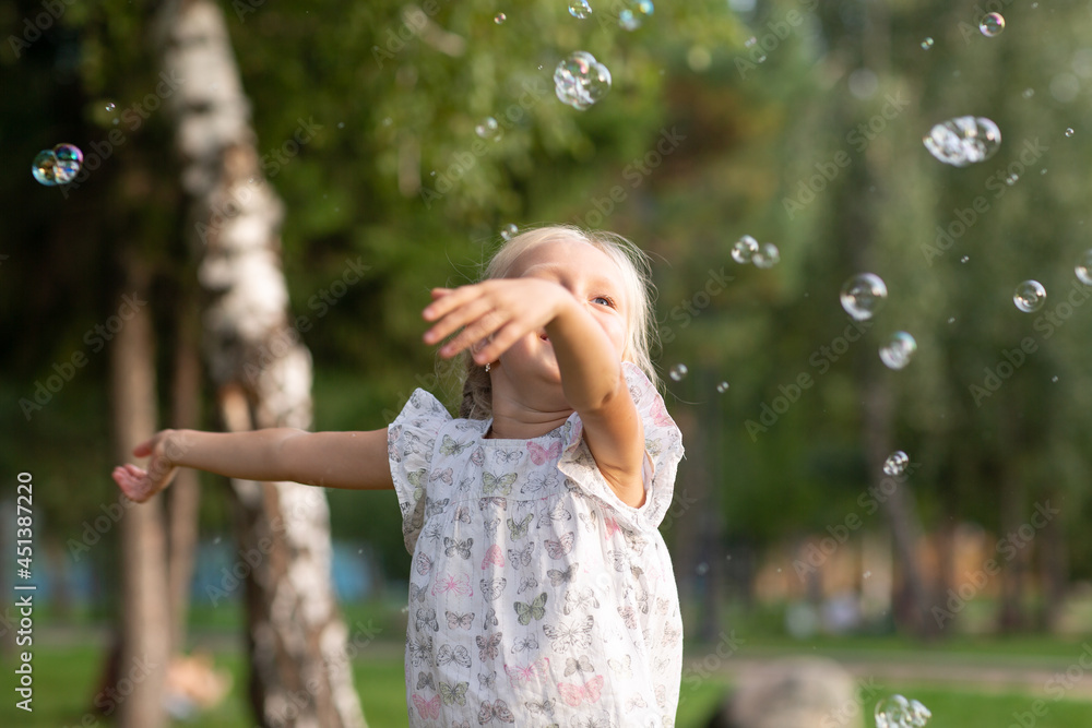 Little cute girl in the summer park blowing bubbles and having fun. Little cute girl in the summer park blowing bubbles and having fun.