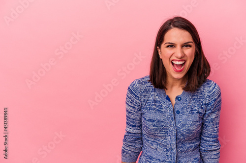 Young caucasian woman isolated on pink background shouting very angry, rage concept, frustrated.