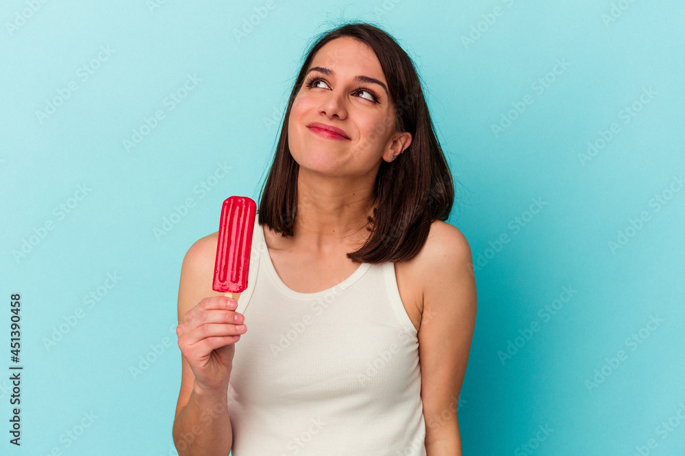 Young caucasian woman holding an ice cream isolated on blue background dreaming of achieving goals and purposes Young caucasian woman holding an ice cream isolated on blue background dreaming of achieving goals and purposes