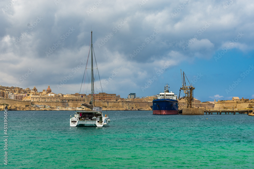 Catamaran  & Tanker in Rinella Bay, Malta with Valletta in the background..