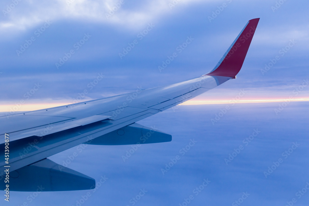 a view from a height above the clouds from the plane's window. part of an airplane wing in the frame a view from a height above the clouds from the plane's window. part of an airplane wing in the frame