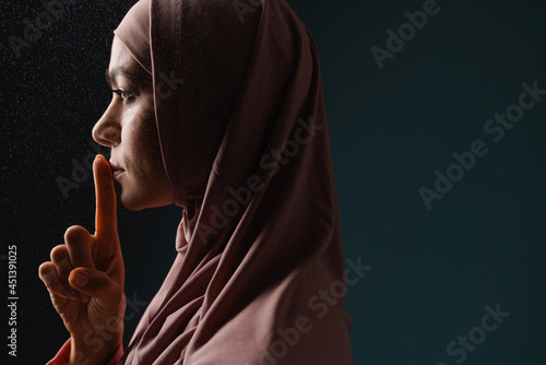 Young muslim woman in hijab showing silence gesture © Drobot Dean