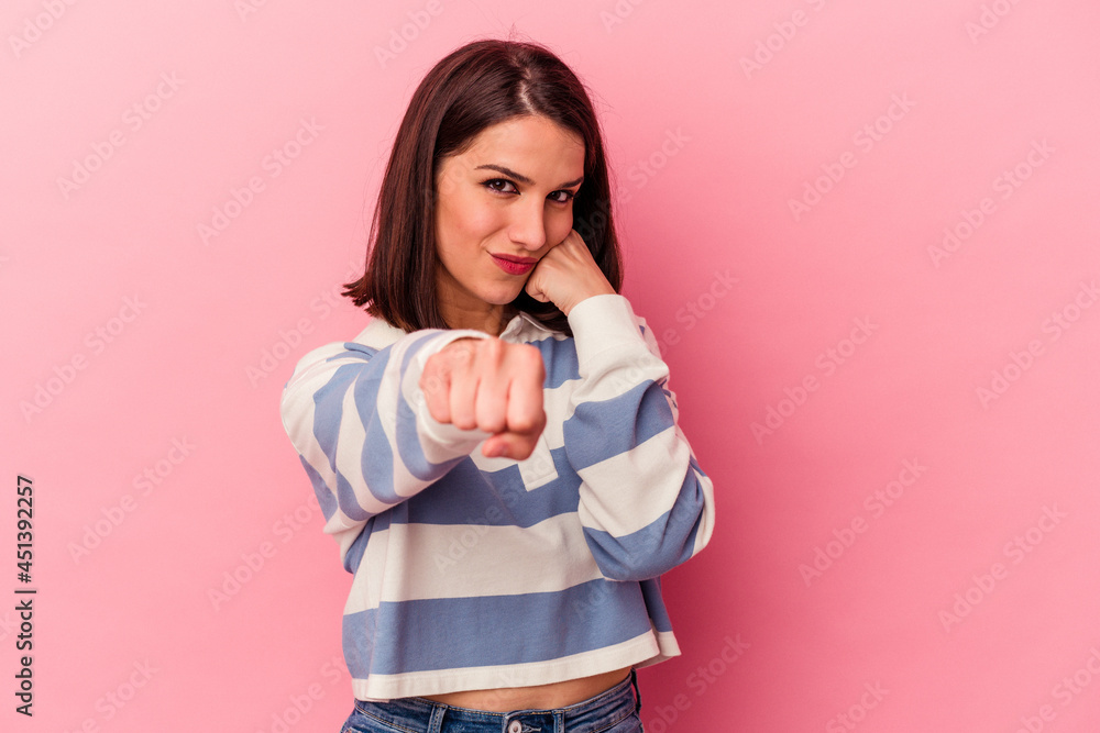 Young caucasian woman isolated on pink background throwing a punch, anger, fighting due to an argument, boxing. Young caucasian woman isolated on pink background throwing a punch, anger, fighting due to an argument, boxing.