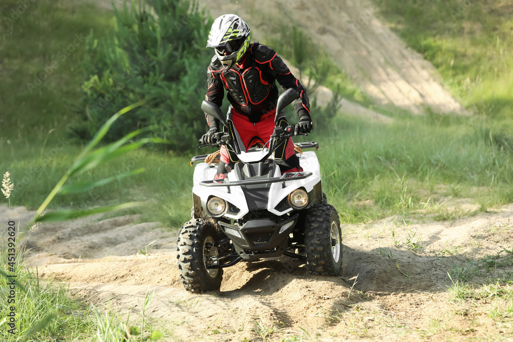 Man driving modern quad bike on sandy road. Extreme sport Man driving modern quad bike on sandy road. Extreme sport