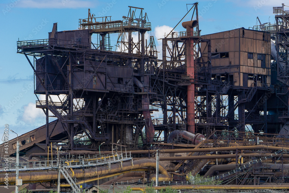 Abandoned structure of an old metallurgical plant. Non-functional plant module, rusty structures and floors.