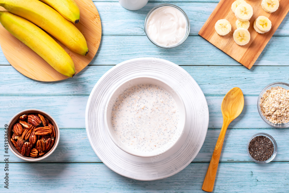 Banana and pecan nuts overnight oatmeal with chia seeds in bowl, rich in protein breakfast or snack Banana and pecan nuts overnight oatmeal with chia seeds in bowl, rich in protein breakfast or snack