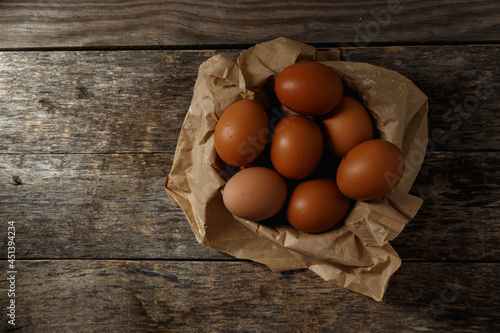 Ecological farm chicken eggs on a rustic wooden table.