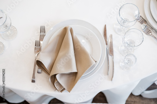 Luxurious wedding table decoration for reception of guests with stylish napkins, cute natural flower. Wedding restaurant decoration