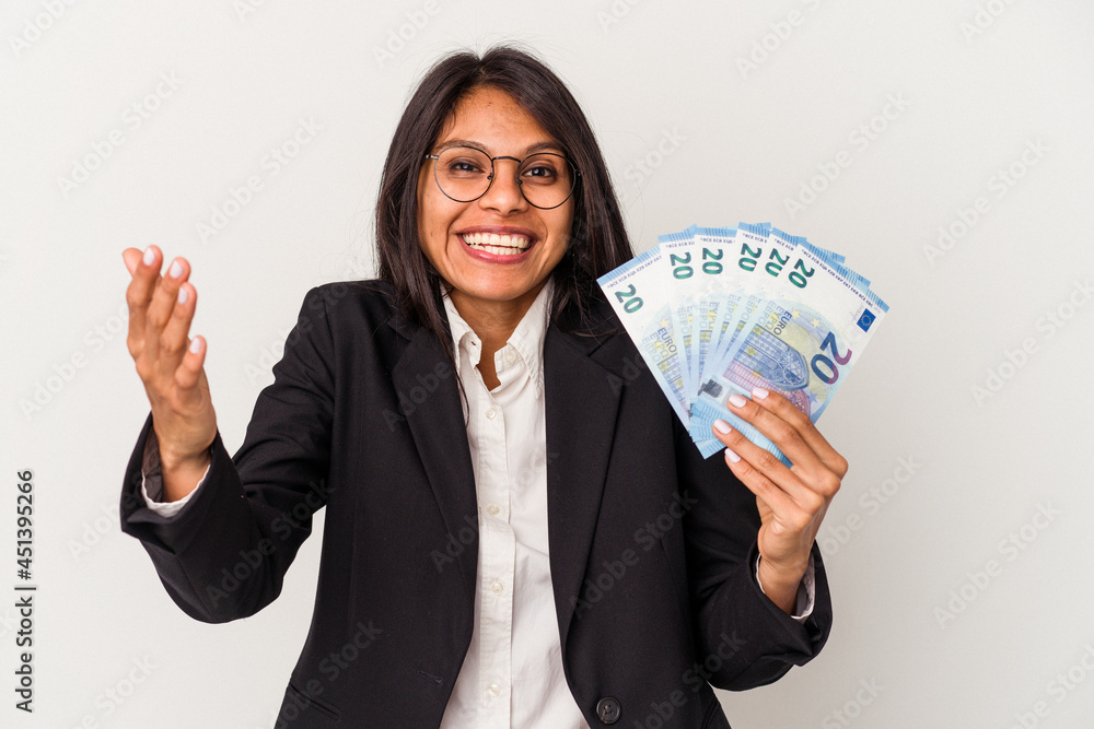 Young business latin woman holding bills isolated on white background receiving a pleasant surprise, excited and raising hands. Young business latin woman holding bills isolated on white background receiving a pleasant surprise, excited and raising hands.