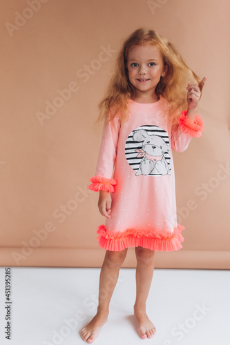 Adorable joyful girl. Funny curly red headed child in studio. Childhood, funny baby girl concept