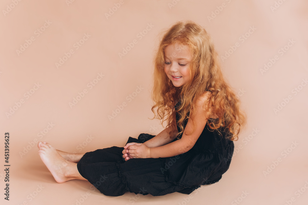 Adorable joyful girl. Funny curly red headed child in studio. Childhood, funny baby girl concept Adorable joyful girl. Funny curly red headed child in studio. Childhood, funny baby girl concept