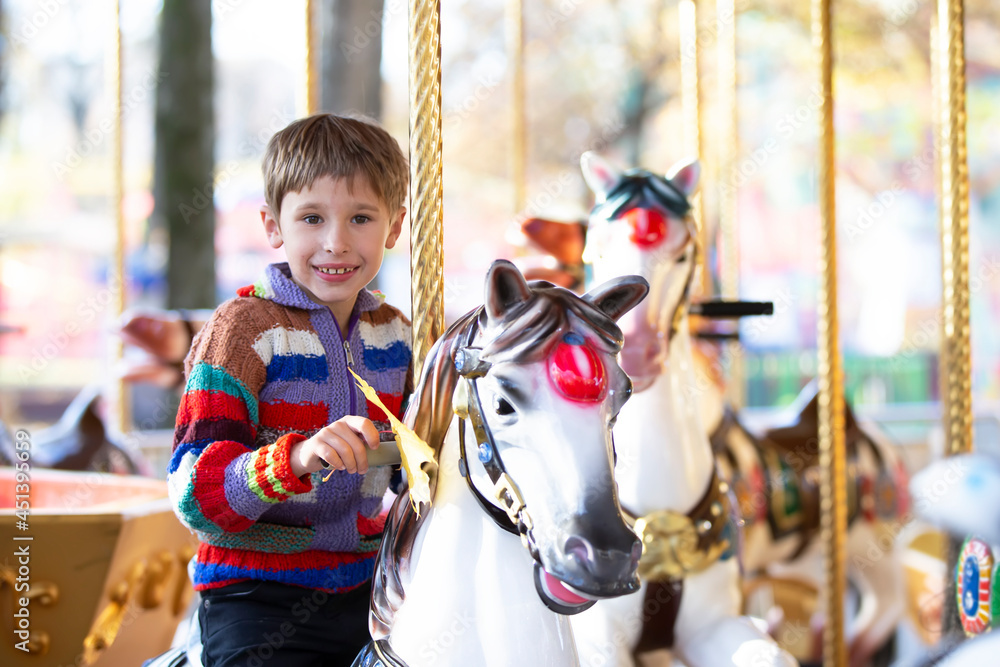 Handsome little boy is riding a carousel. A child on a horse carousel. Handsome little boy is riding a carousel. A child on a horse carousel.