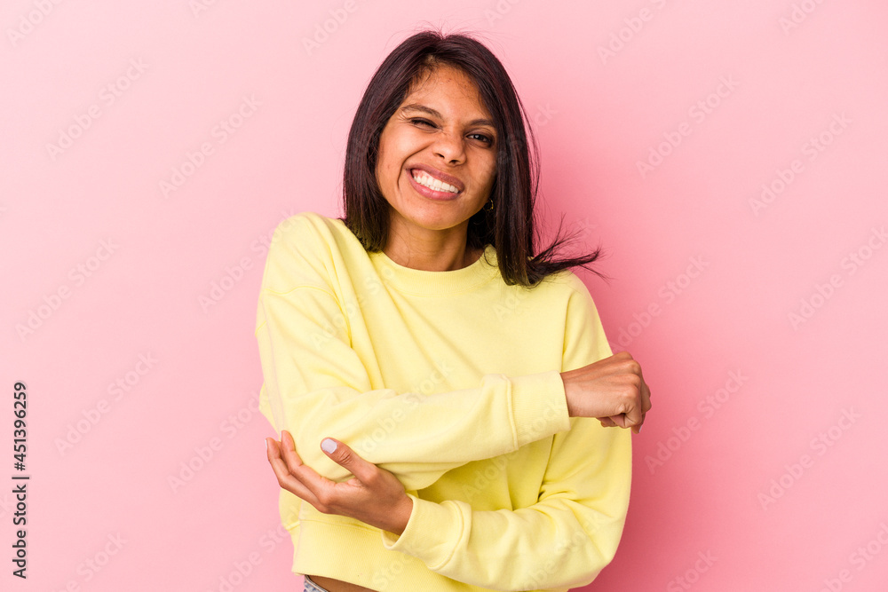 Young latin woman isolated on pink background massaging elbow, suffering after a bad movement. Young latin woman isolated on pink background massaging elbow, suffering after a bad movement.