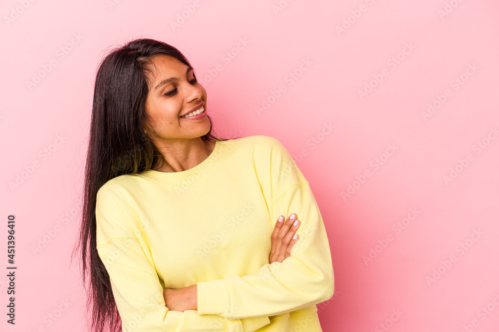 Fototapeta premium Young latin woman isolated on pink background smiling confident with crossed arms.