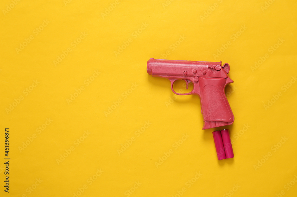Pink pistol with aa batteries on pink background. Concept art. Minimalism Pink pistol with aa batteries on pink background. Concept art. Minimalism