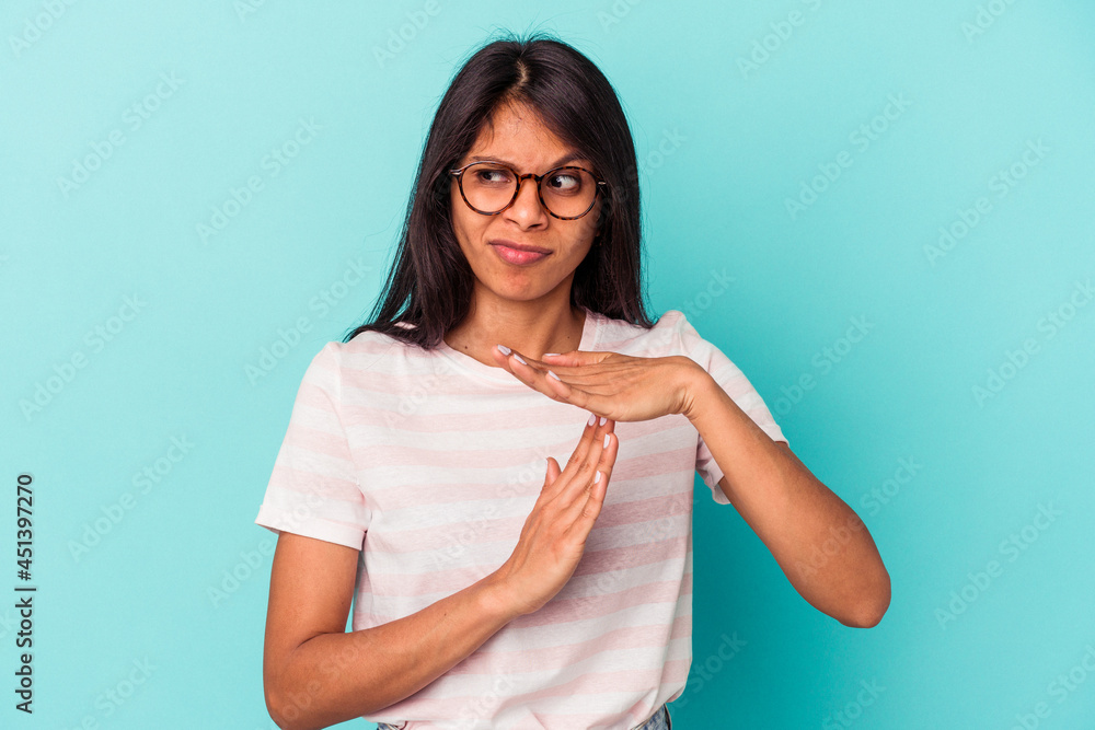 Young latin woman isolated on blue background showing a timeout gesture.