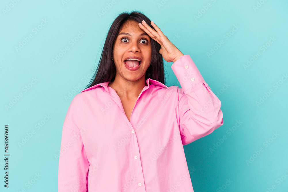 Young latin woman isolated on blue background shouts loud, keeps eyes opened and hands tense. Young latin woman isolated on blue background shouts loud, keeps eyes opened and hands tense.