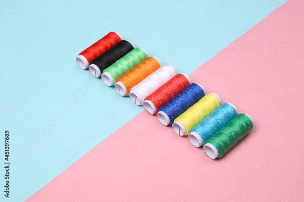 Skeins of colored thread on a blue-pink pastel background Skeins of colored thread on a blue-pink pastel background