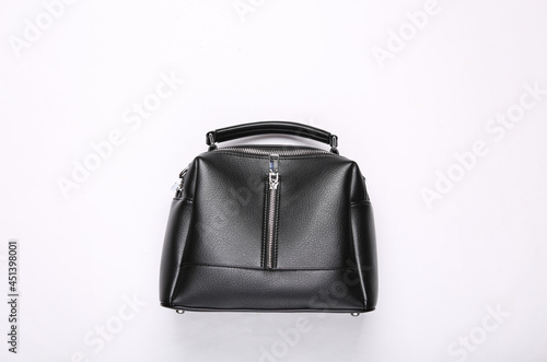 Fashionable leather black handbag on white background. Top view
