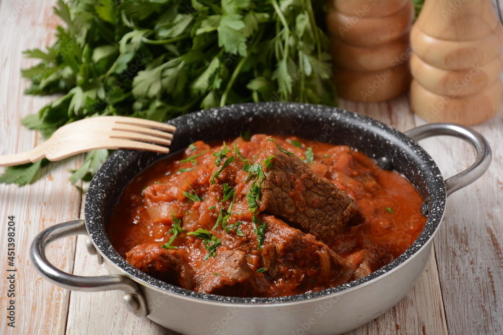 Beef meat stew. Overhead view braised beef meat stew in tomato sauce with herbs