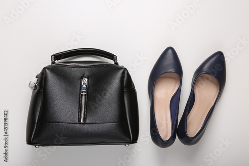 Leather shoes with heels and a handbag on white background. Women's accessories. Top view