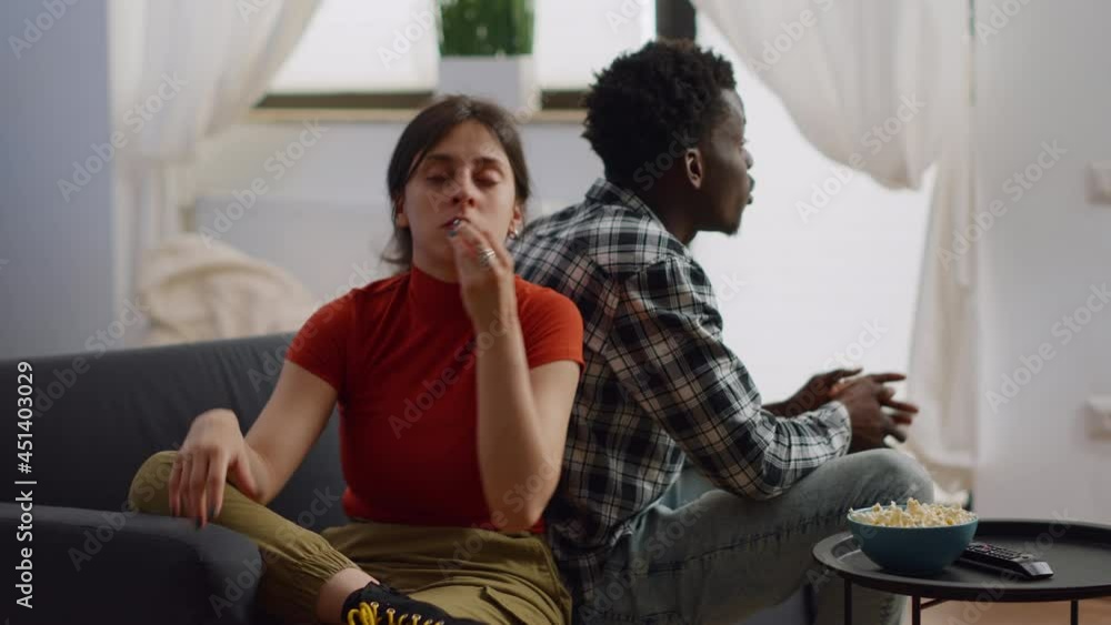 Interracial couple shouting at each other having argument in living room. Angry multi ethnic people fighting about marriage issues while sitting together on couch at home. Irritated lovers Interracial couple shouting at each other having argument in living room. Angry multi ethnic people fighting about marriage issues while sitting together on couch at home. Irritated lovers