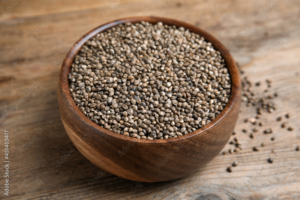 Bowl with organic hemp seeds on wooden table, closeup Bowl with organic hemp seeds on wooden table, closeup