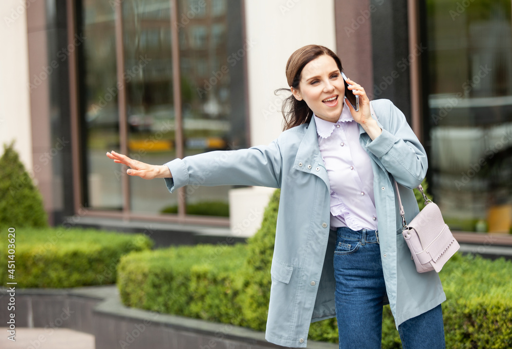 Cute lady catches car in city and talks on the phone