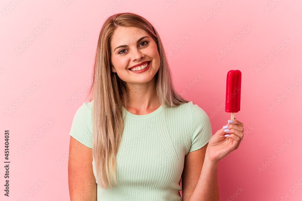 Young russian woman holding an ice cream isolated on pink background happy, smiling and cheerful. Young russian woman holding an ice cream isolated on pink background happy, smiling and cheerful.