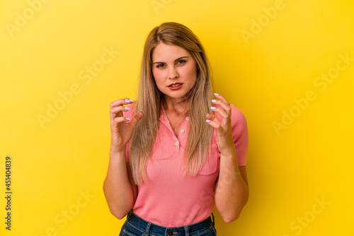 Young russian woman isolated on yellow background upset screaming with tense hands.