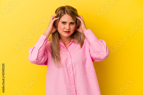 Young russian woman isolated on yellow background crying, unhappy with something, agony and confusion concept.