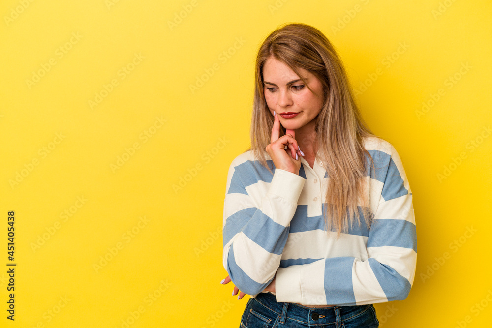 Young russian woman isolated on yellow background looking sideways with doubtful and skeptical expression. Young russian woman isolated on yellow background looking sideways with doubtful and skeptical expression.