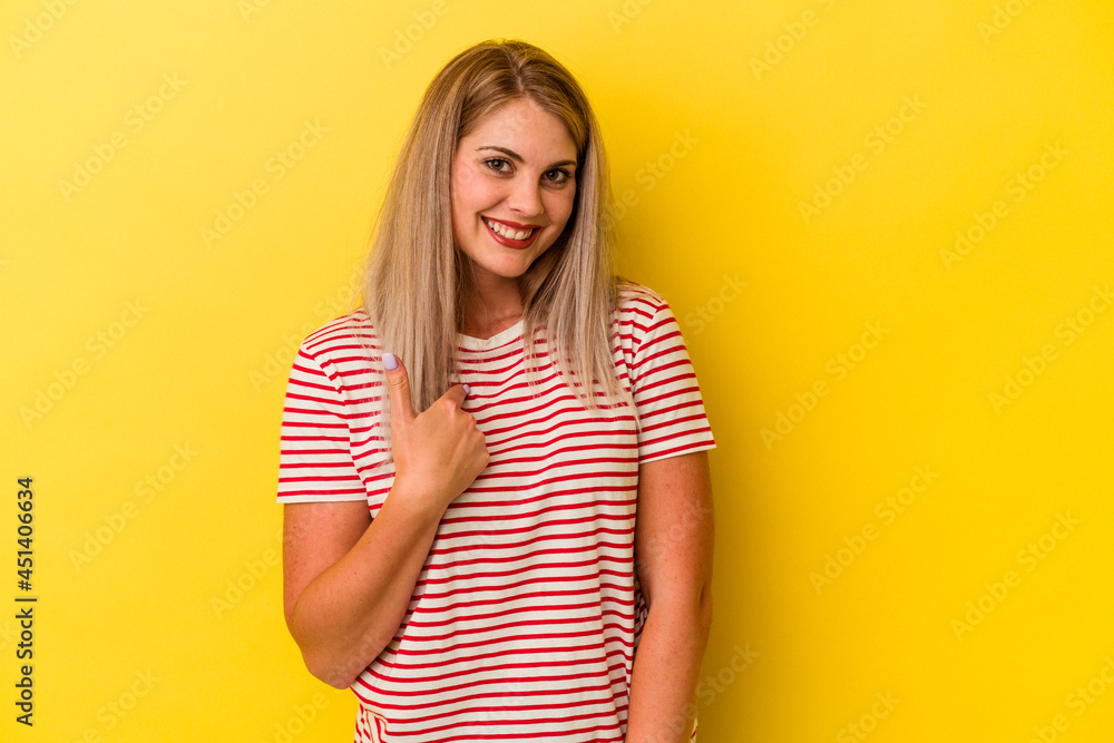 Young russian woman isolated on yellow background surprised pointing with finger, smiling broadly. Young russian woman isolated on yellow background surprised pointing with finger, smiling broadly.