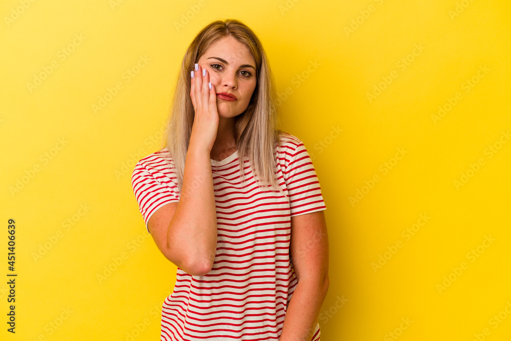 Young russian woman isolated on yellow background tired and very sleepy keeping hand on head. Young russian woman isolated on yellow background tired and very sleepy keeping hand on head.