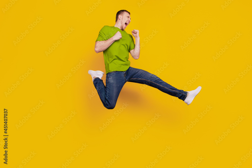 Full size profile side photo of young guy angry mad crazy fight conflict kick isolated over yellow background