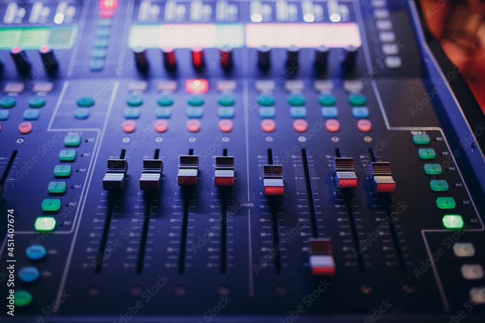 Mixing console, hand equalizing audio sound channels in night club. Mixing console, hand equalizing audio sound channels in night club.
