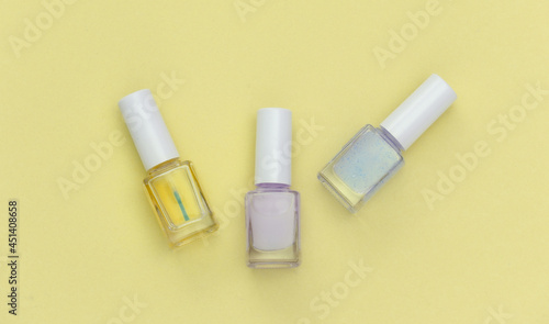 Nail polish bottle on yellow background. Beauty concept. Top view