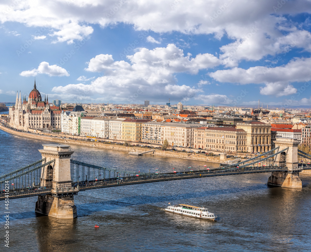 Panorama of Budapest with chain bridge, building of parliament and tourist boat on Danube river in Hungary
