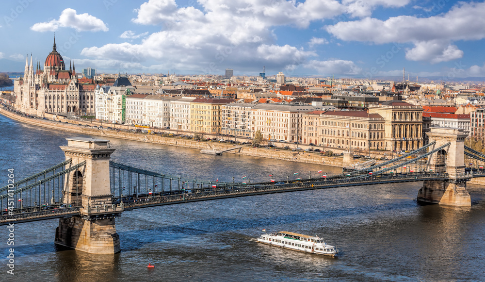 Obraz premium Panorama of Budapest with chain bridge, building of parliament and tourist boat on Danube river in Hungary