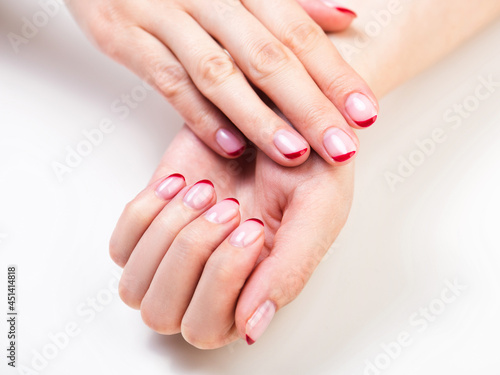 Female hands with a trendy autumn french manicure photo