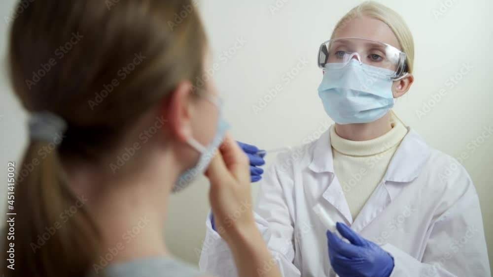 Hospital female employee at laboratory room closeup. PCR throat sample for corona virus test by medicine nurse indoors. Hospital female employee at laboratory room closeup. PCR throat sample for corona virus test by medicine nurse indoors.