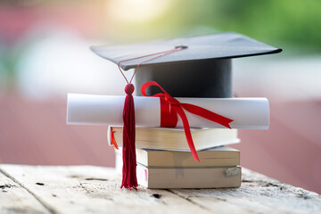 Close-up selective focus of a graduation cap or mortarboard and diploma degree certificate put on table