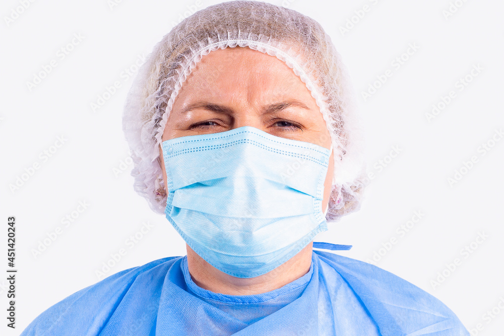 Close up photo of a medical nurse in a blue uniform and face disposable mask tired of too much work on pandemic time. Close up photo of a medical nurse in a blue uniform and face disposable mask tired of too much work on pandemic time.