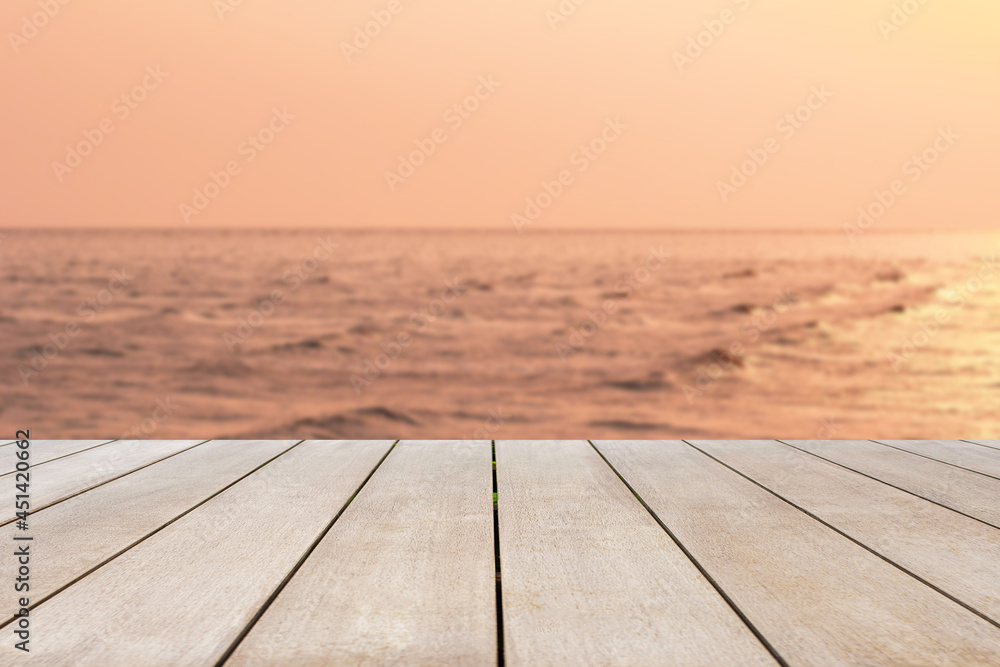 Empty old wooden table in front of blurred background of the sea at sunset. Can be used for display or montage for show your products..