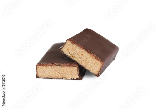 Halves of tasty chocolate glazed protein bar on white background