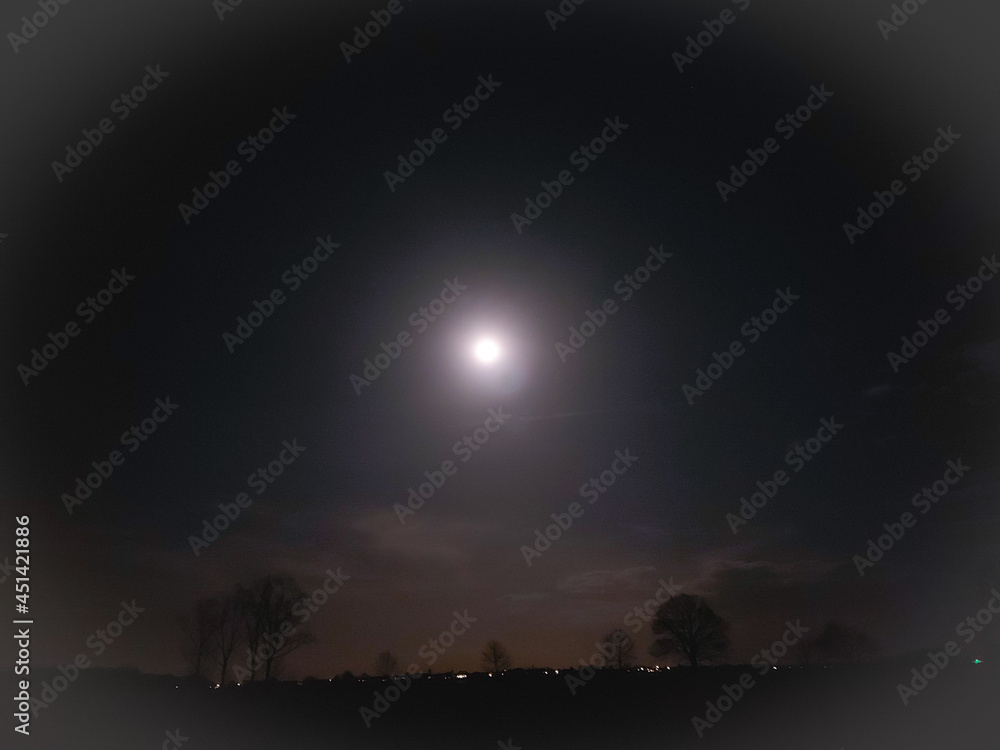 Ein Vollmond erhellt die Nacht über einem verschlafenen Dorf. Ein Vollmond erhellt die Nacht über einem verschlafenen Dorf.