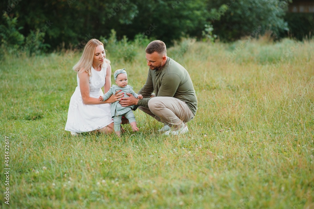 Fototapeta premium Happy young family spending time together outside in green nature.
