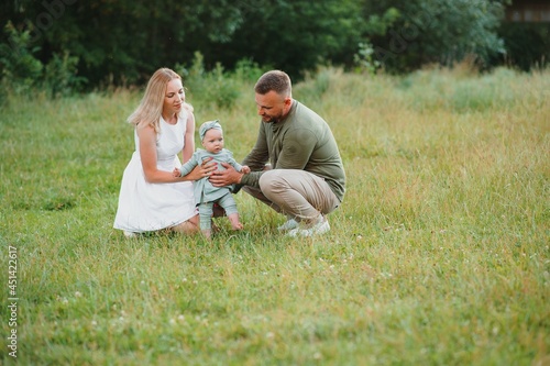 Happy young family spending time together outside in green nature.