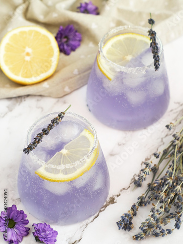 Glasses of fresh colorful sparkling lavender-lemonade drink with salt and sugar on the edge of glass for summer time. Lavender is kind of the swiss army knife of home remedies and many health benefits