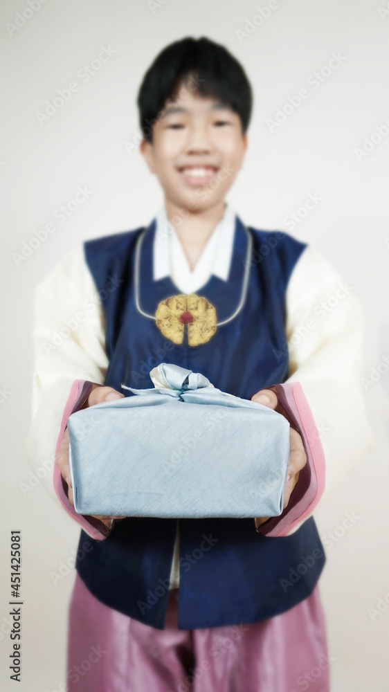 한복을 입고 웃으며 선물을 들고있는 소년 A smiling boy wearing a hanbok and holding a gift 한복을 입고 웃으며 선물을 들고있는 소년 A smiling boy wearing a hanbok and holding a gift
